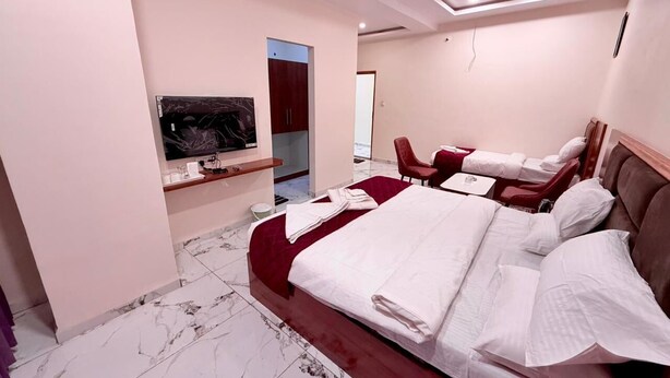 Een hotelkamer met een groot bed, een televisie, een bureau en een stoel.