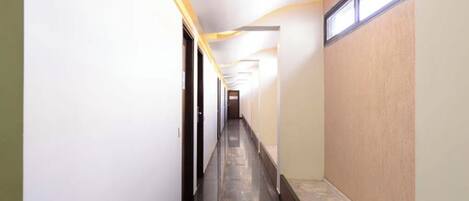 A long, narrow hallway with a wooden floor and white walls.