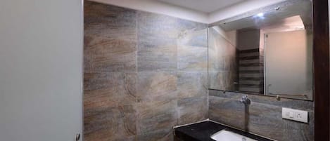 Ein Badezimmer mit Steinwand, Waschbecken und Spiegel.