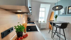 Une cuisine moderne dotée d’un plan de travail en bois, d’une cuisinière intégrée et d’un coin repas avec une table et des chaises.