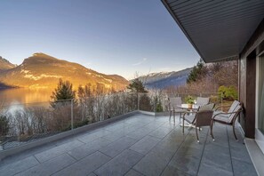 A balcony with a view of mountains and a lake.