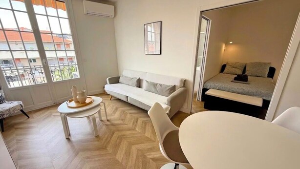 A compact living space with a sofa, a dining table, and a bed. - Appartement de standing -centre- ville de Nice (Nice)