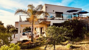 A modern two-story house with a balcony, a driveway, and a car parked in front. - Villa Livia swimming pool, Beach 500 m, sea view (Albitreccia)