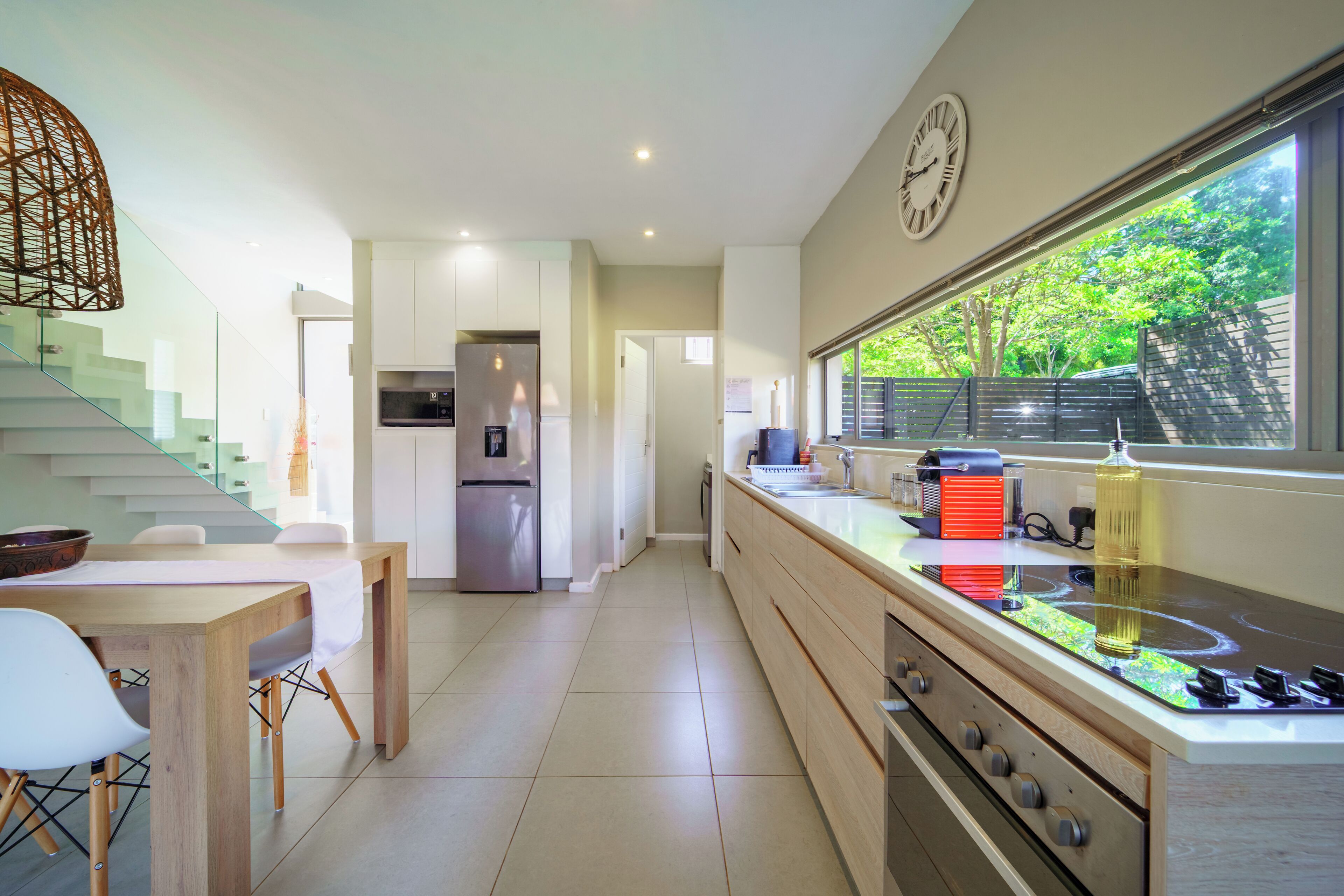 Une cuisine moderne équipée d’une cuisinière intégrée, d’un réfrigérateur et d’un coin repas avec une table et des chaises.