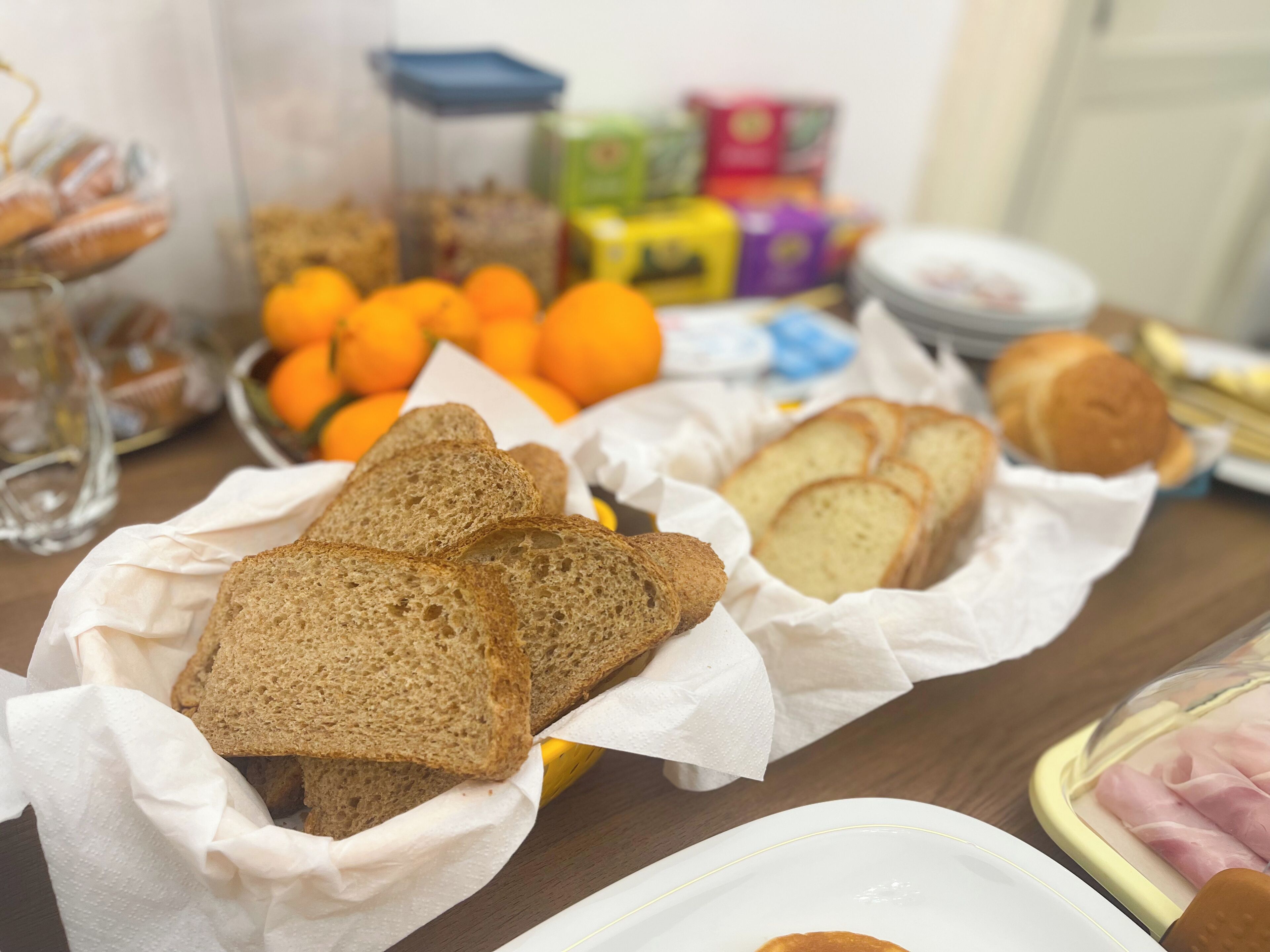 Taula amb diferents aliments, com ara pa, taronges i productes envasellats.