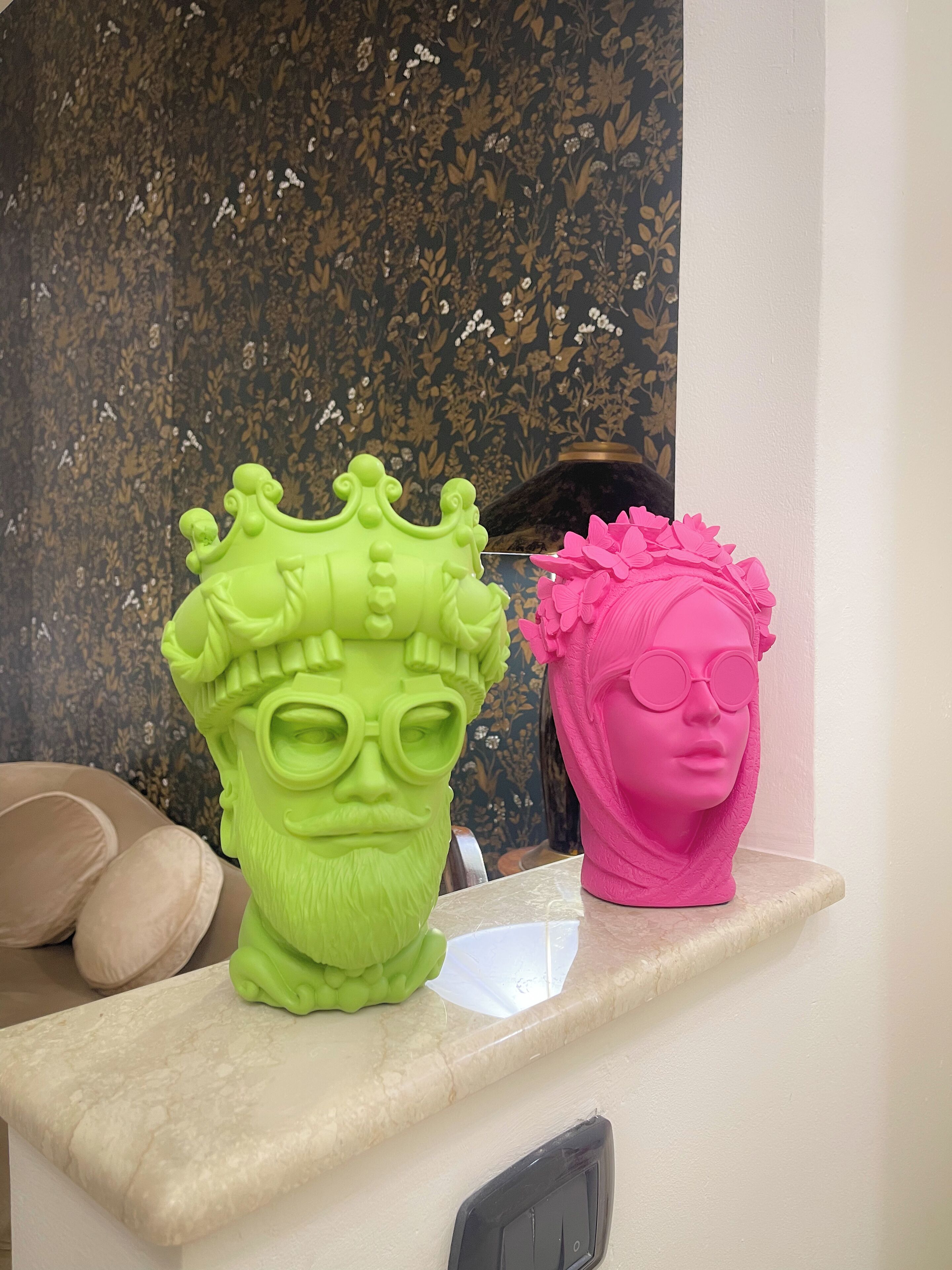 Two decorative head sculptures on a shelf.