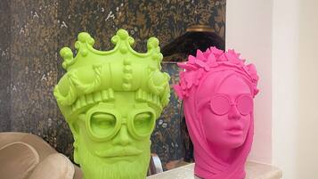 Two decorative head sculptures on a shelf.