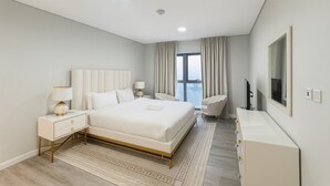 Ett modernt hotellrum med en stor säng, sängbord, ett skrivbord och en stol.