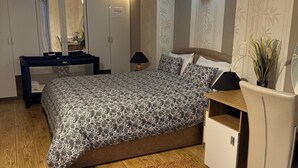 Una camera da letto con un letto, un comodino, un armadio e uno specchio.