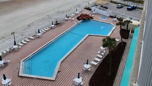 Una piscina con lettini e vista sulla spiaggia.
