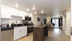 Una cocina moderna con armarios blancos, microondas y una isla central.