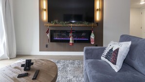 Una sala de estar moderna con chimenea, un sofá y una mesa de centro.