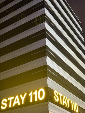 A hotel sign with "STAY 110" illuminated in bright yellow letters. - STAY110 (Seoul)