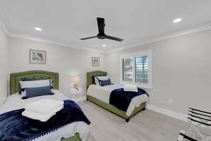 A hotel room with two beds, a ceiling fan, a window with blinds, and artwork on the walls. - Beachfront 2B/2B Sandarac Vacation Condo 506B. Direct gulf view! (Fort Myers Beach)