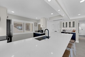 Una cocina moderna con una isla central, electrodomésticos integrados y una zona de bar.