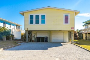 A two-story house with a garage, a front porch, and a small deck. - Good Company - Classic 3BR Oceanfront Beach Cottage with Screen Porch (Topsail Beach)