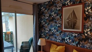 Une chambre d’hôtel comprenant un lit, une table de chevet avec une lampe, une chaise et un balcon avec une table et des chaises.