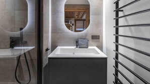 Une salle de bain moderne avec un lavabo rectangulaire, un miroir et un espace douche.