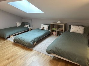 A bedroom with two beds, a skylight, a bookshelf, and a small table. - New apt 3 br 8 ppl near rink with balcony and parking (Arâches-la-Frasse)