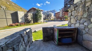 A stone wall with a wooden bench and a blue container. - Comfort studio 28m² for 2 in Tignes Val Claret (Tignes)