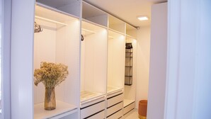 A walk-in closet with open shelving and drawers, a vase with flowers, and a mirror. - Luxury Villa in Valencia, exclusive style, relax and enjoy (Llíria)