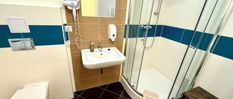 A bathroom with a toilet, sink, and glass-enclosed shower.