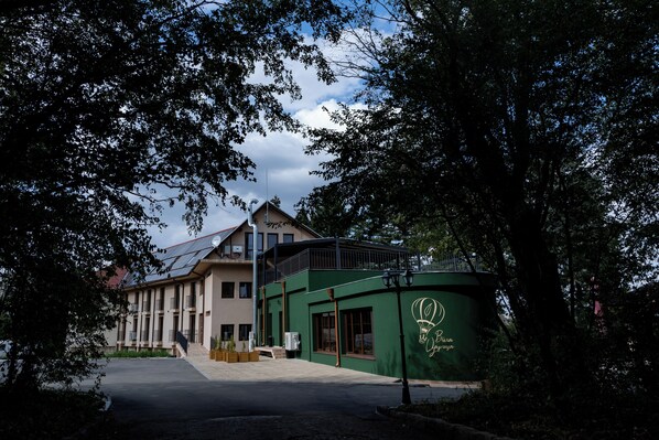 A building with a green facade and a balcony, surrounded by trees. - Queen's cottage (Shumen)