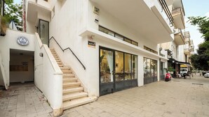 Un bâtiment moderne doté d’un escalier menant à l’entrée, de grandes fenêtres et d’une enseigne indiquant la présence d’un restaurant.