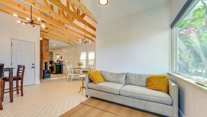 A spacious living area with a sofa, a dining table with chairs, a fireplace, and a large window. - Vintage Home w/ Easy Downtown Tampa Access (Tampa)
