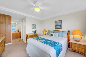 A bedroom with a bed, bedside lamps, a ceiling fan, and a painting on the wall. - Oceanfront Royal Mauian #515 - 2BR/2BA with Panoramic Views Near Kamaole Beaches (Kihei, Maui)