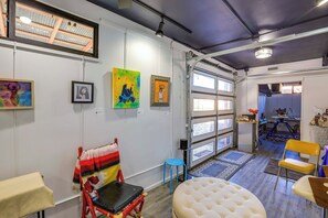 A spacious room with a large window, a white cushioned bench, a small stool, and a colorful painting on the wall. - 5 Mi to Coors Field & Lodo: North Denver Studio (Denver)