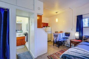 A compact bedroom with a bed, a small desk, and a kitchenette. - 5 Mi to Coors Field & Lodo: North Denver Studio (Denver)