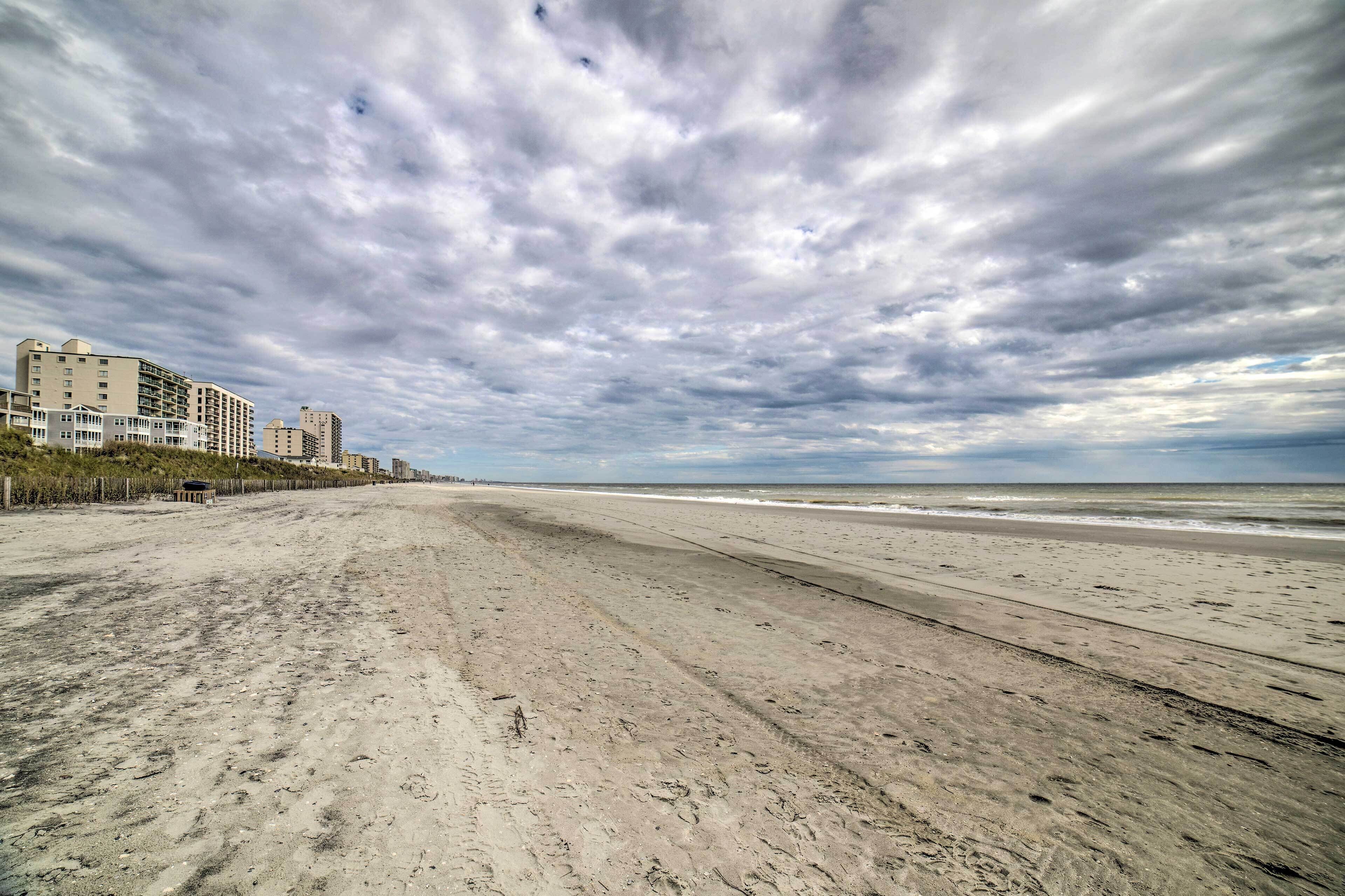 Una playa con una hilera de edificios al fondo.