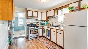 A kitchen with wooden cabinets, a stove, a microwave, and a refrigerator.
