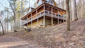 Un'ampia baita di legno con un balcone, immersa nel verde.