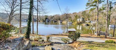 A lakeside property with a dock, stone steps, and a small gazebo.