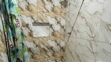 A bathroom with a toilet, shower, and a bathtub.