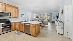 A spacious kitchen with wooden cabinets, a built-in oven, and a large island. - AVF 102-101 Spacious 4BR Condo w/ Pool Access – Avian Forest 102-101 (Pawleys Island)