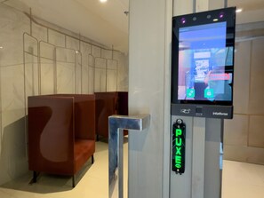 Des toilettes publiques équipées d’un kiosque numérique, d’un bouton-poussoir et d’un espace où l’on peut s’asseoir.