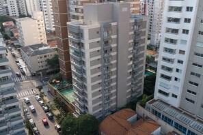 A high-rise building with multiple balconies, a street with cars, and adjacent buildings. - Glass Art 96 (São Paulo)