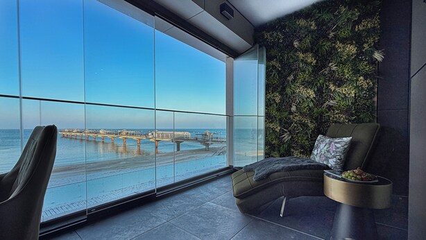 A modern room with a large window overlooking a pier and the sea. - Baltic Infinity (Międzyzdroje)