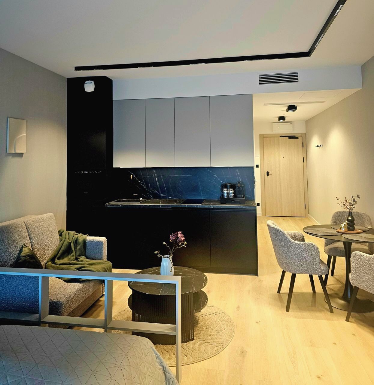 Una sala de estar moderna con un sofá, una mesa de centro y un comedor con sillas.