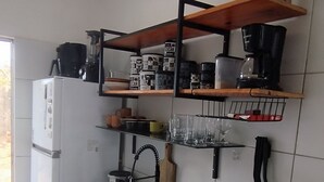 Eine moderne Küche mit schwarzem Arbeitsplatz, weißen Schränken, einem eingebauten Herd und einer Kaffeemaschine.