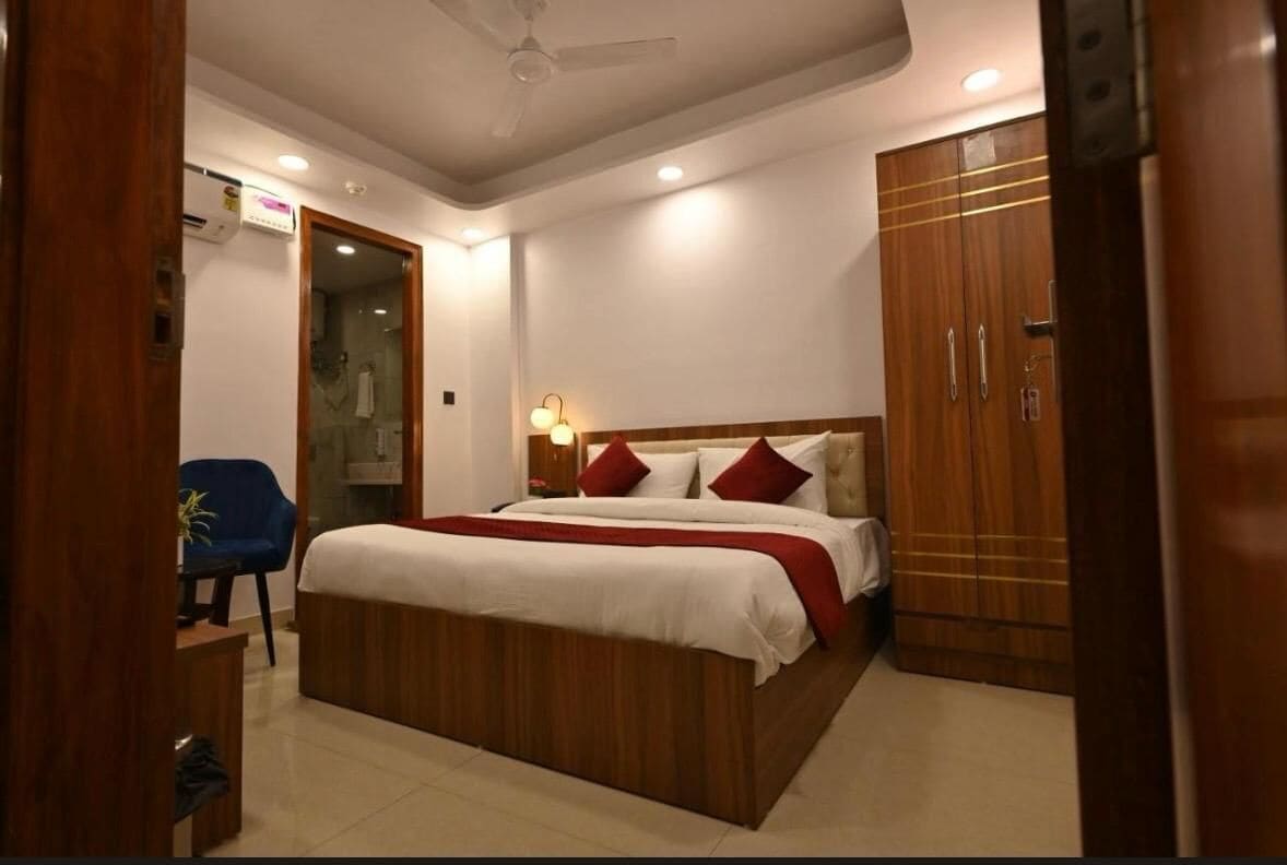 A bedroom with a wooden bed, a wardrobe, a desk, and a chair.
