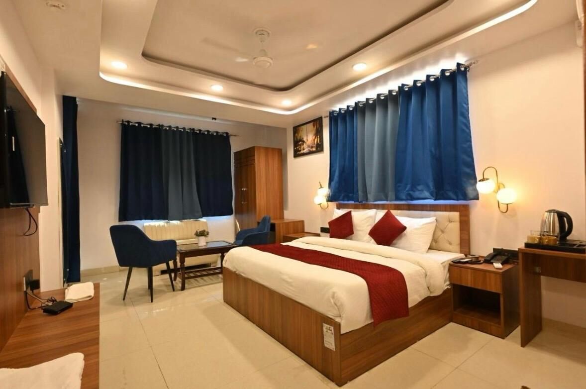Une chambre d’hôtel comprenant un lit, une table de chevet, une lampe et un bureau avec une chaise.