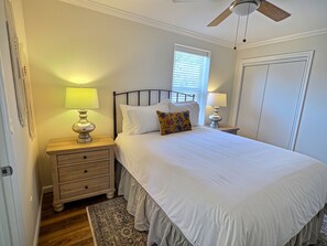 A bedroom with a bed, two bedside tables with lamps, a ceiling fan, a window with blinds, and a door. - Sky Blue 2Bdrm Guest House | Country Escape | Minutes to Beaches & Wineries (Arroyo Grande)