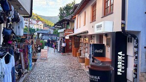 Eine Kopfsteinpflasterstraße mit Geschäften, darunter ein Café namens Fabrika Coffee.