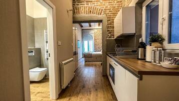 Suite monolocale Deluxe, non fumatori, bagno privato | Una cassaforte in camera, una scrivania, ferro/asse da stiro