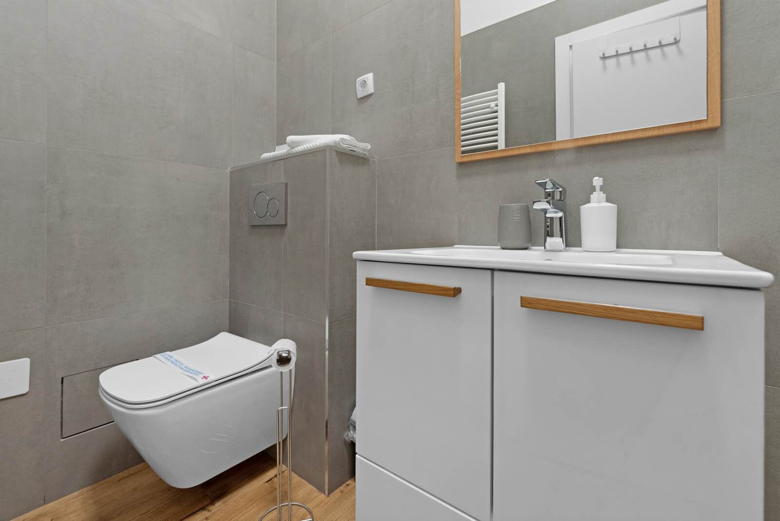 A modern bathroom with a toilet, shower, and sink.