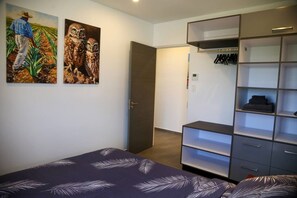 Ein Schlafzimmer mit einem Bett, einem Kleiderschrank und zwei Bildern an der Wand.